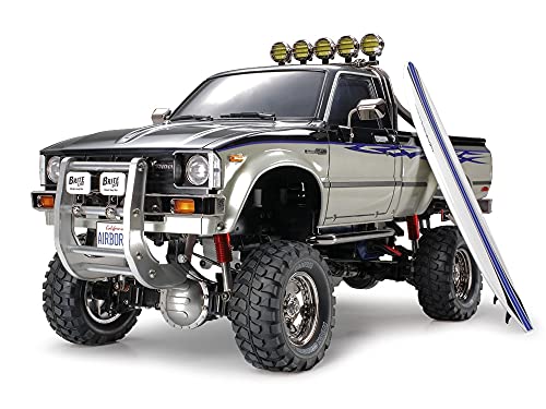 TAMIYA TMYTAM58397 1:10 RC Toyota HiLux HighLift 4x4 3-Gang - ferngesteuertes Auto - inkl. Surfbrett - Offroad - Pick Up -Elektromotor - Modellbausatz - Metallgetriebe - unlackiert - 58397, Schwarz von TAMIYA